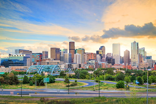 a view of the denver skyline as the sun begins to set